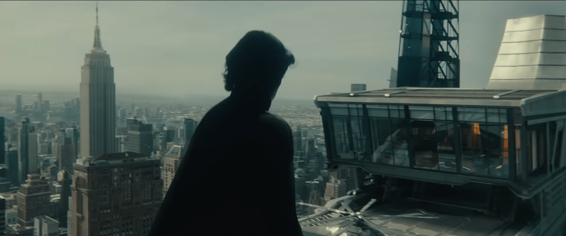 A silhouetted figure of Sentry, portrayed in shadow, floating near a high-rise tower overlooking the New York City skyline, including the Empire State Building.