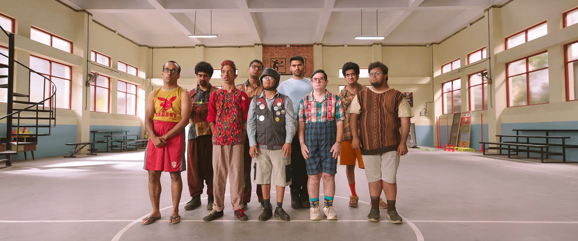 The entire special-needs basketball team stands in a straight line on the court, posing awkwardly during training.
