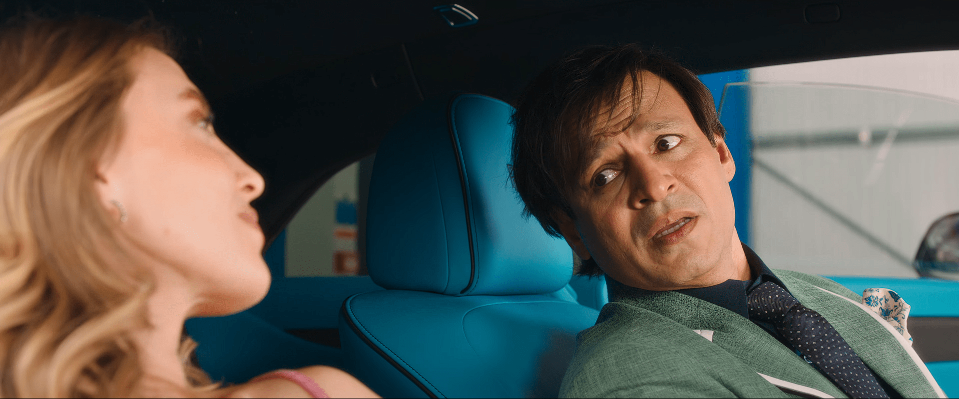Inside a car, Vivek Oberoi looks confused and worried while talking to a foreign actress sitting beside him in the passenger seat.